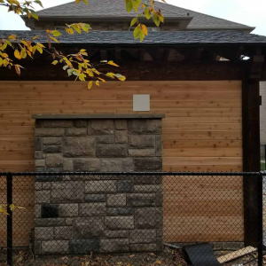 Back View Of Pergola With Stone Fireplace Wall